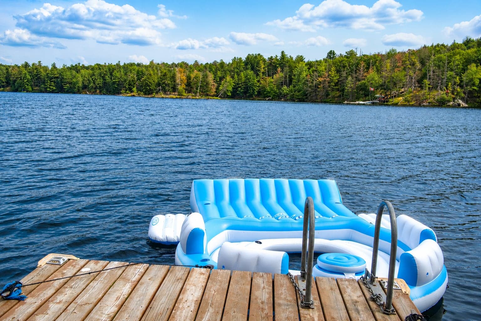 Blue chairs on the dock at Birch Island Cottage looking across Sand Lake
