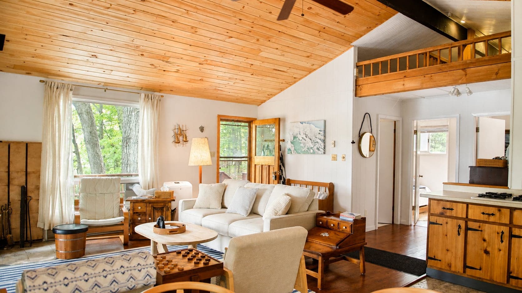 The vaulted living room at Birch Island Cottage with wood ceilings and lake light
