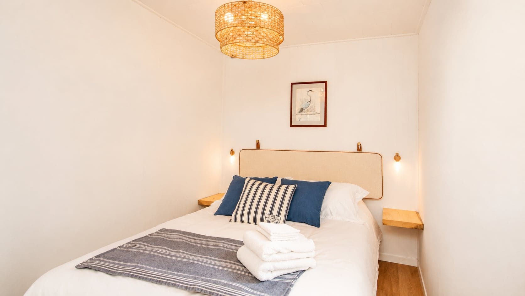 The main bedroom at Birch Island Cottage with a queen bed and warm wood walls